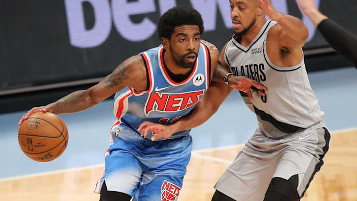 Brooklyn Nets point guard Kyrie Irving (11) controls the ball against Portland Trailblazers shooting guard CJ McCollum.